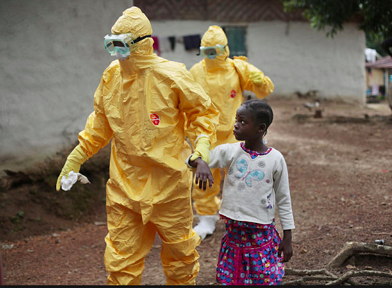 A kid led by hazmat suited men